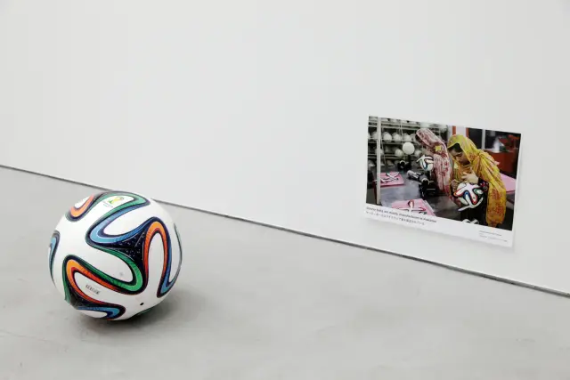 “Soccer ball and Its Process”. Soccer ball, photograph print on paper. 2018. Text: “Soccer balls are mostly manufactured in Pakistan”