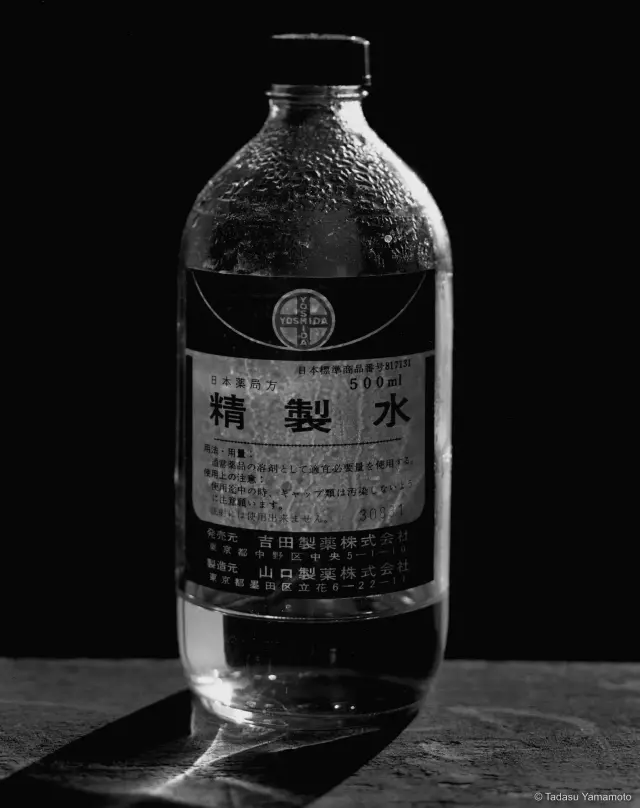 《Bottles 精製水》(1982) ゼラチンシルバー・プリント、H50×W60cm